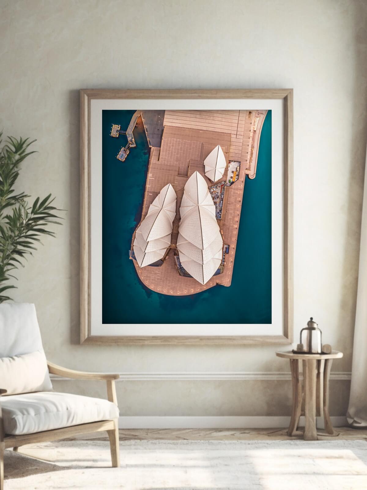 Framed drone print of Sydney Opera House from above in a beach style diner room.