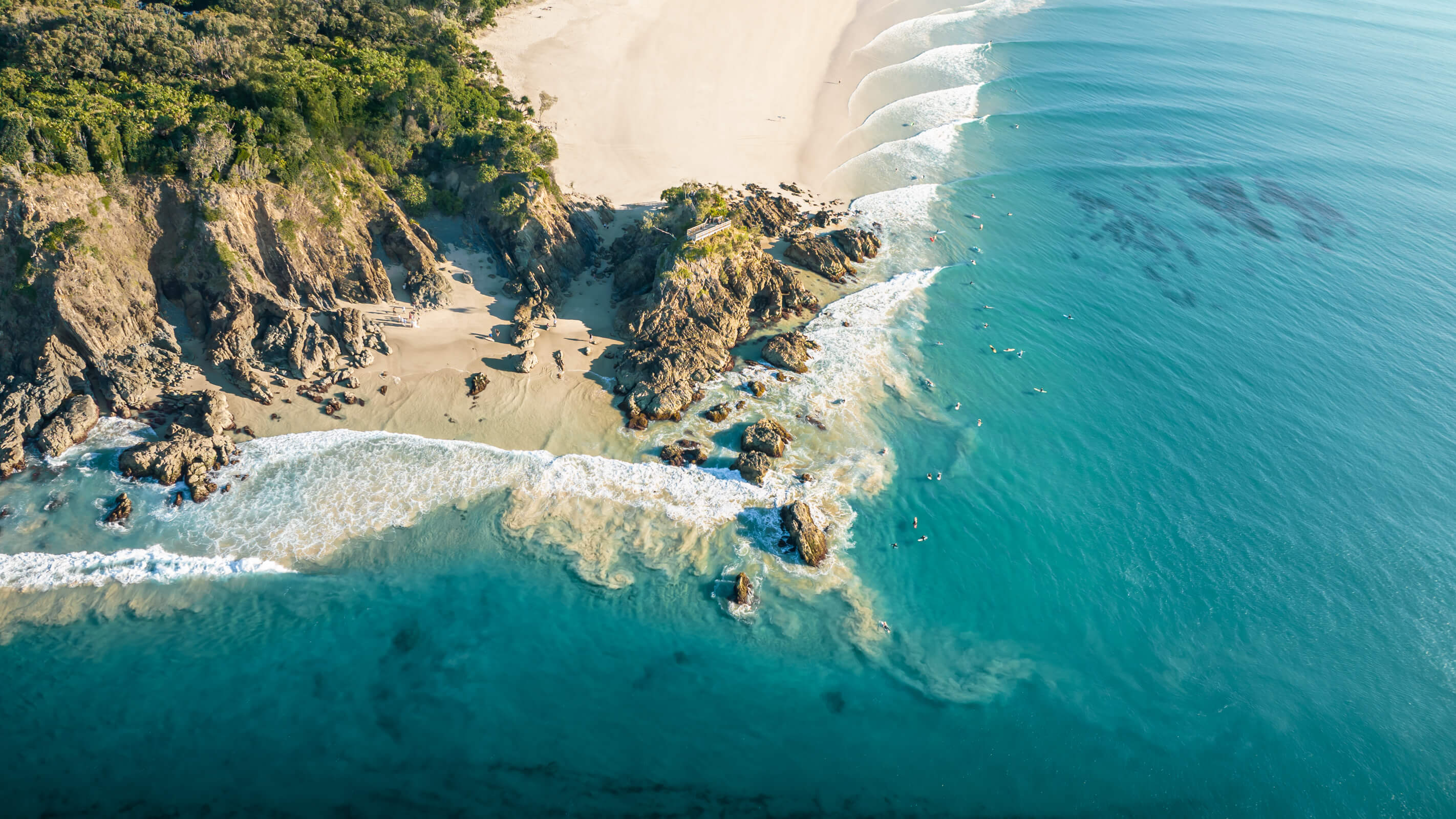 A photo of the Pass in Byron Bay showing the coast and surfers from above