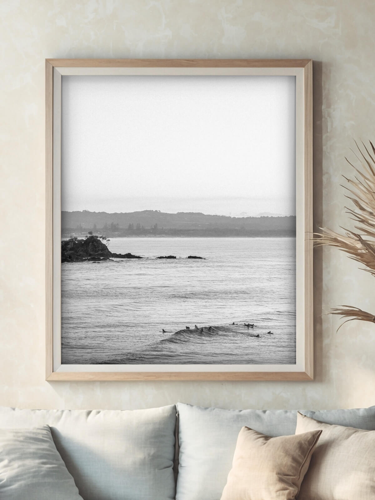 Framed black and white photograph of surfers waiting on calm waves near Byron Bay, capturing a tranquil coastal scene.