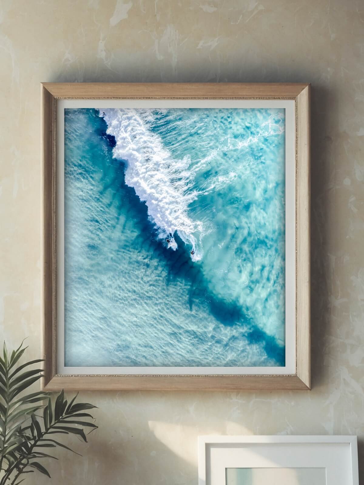 Framed print of twin surfers riding a wave in Bondi Beach, captured from above.