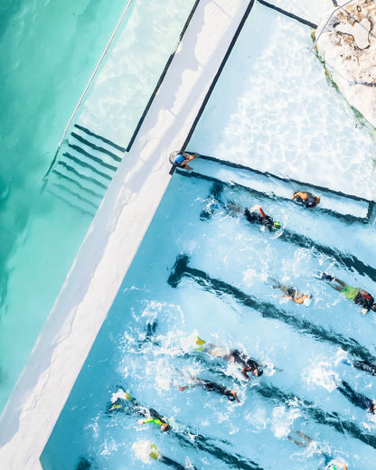 Aerial photo of swimmers in the Bondi Icebergs Pool, Sydney, with turquoise water and pool lanes in view.