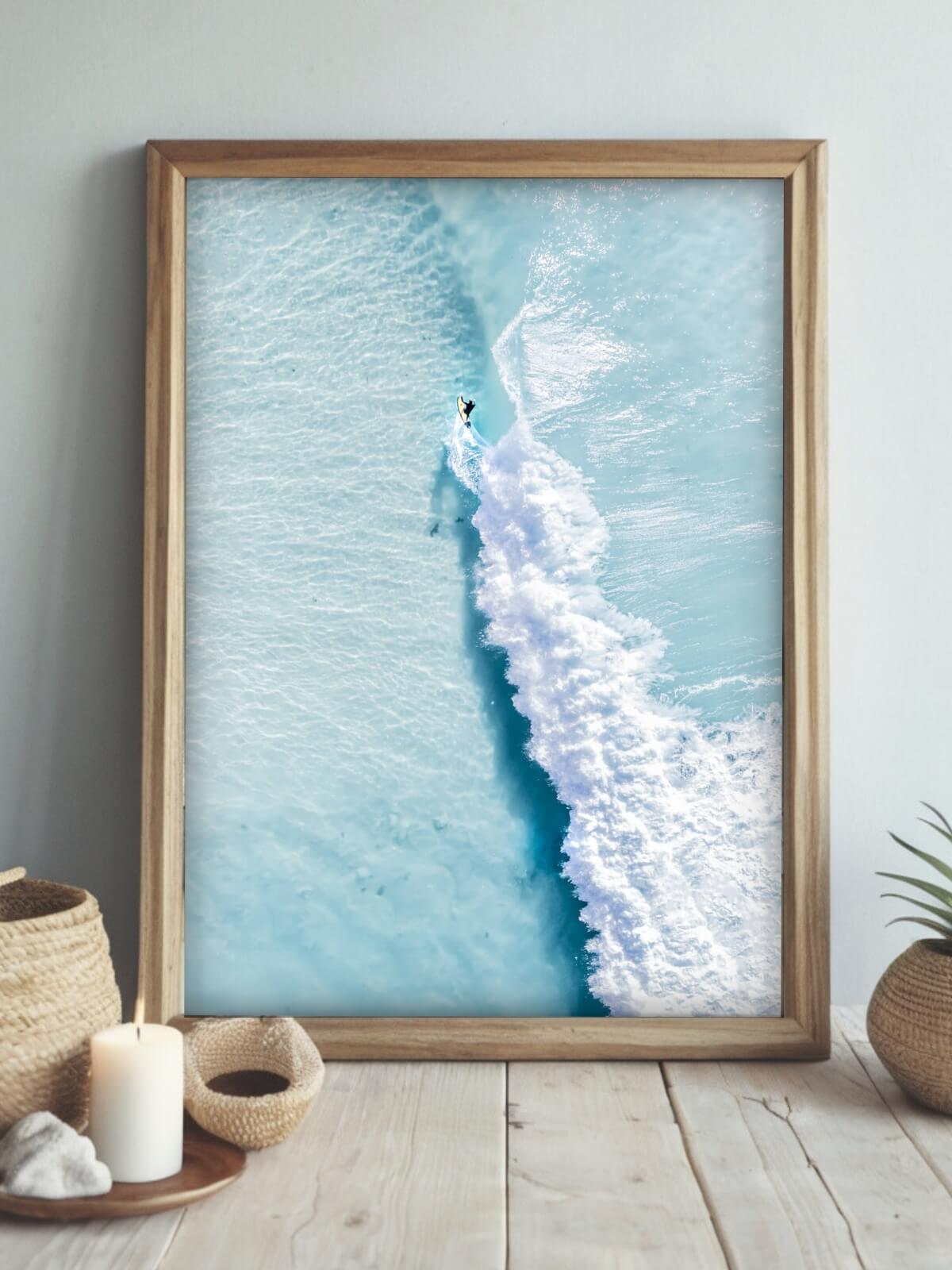 Framed coastal print of a surfer riding waves at Byron Bay’s The Pass with turquoise water.