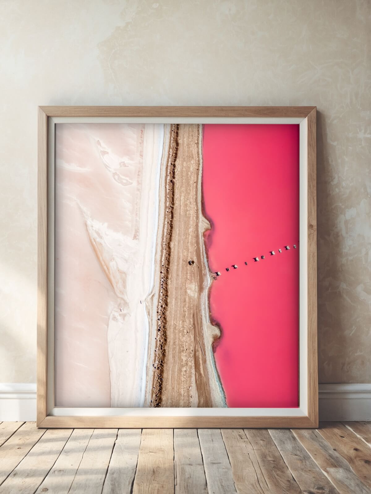 Framed print of Hutt Lagoon, the pink lake in Western Australia, featuring vivid pink water from an aerial perspective.