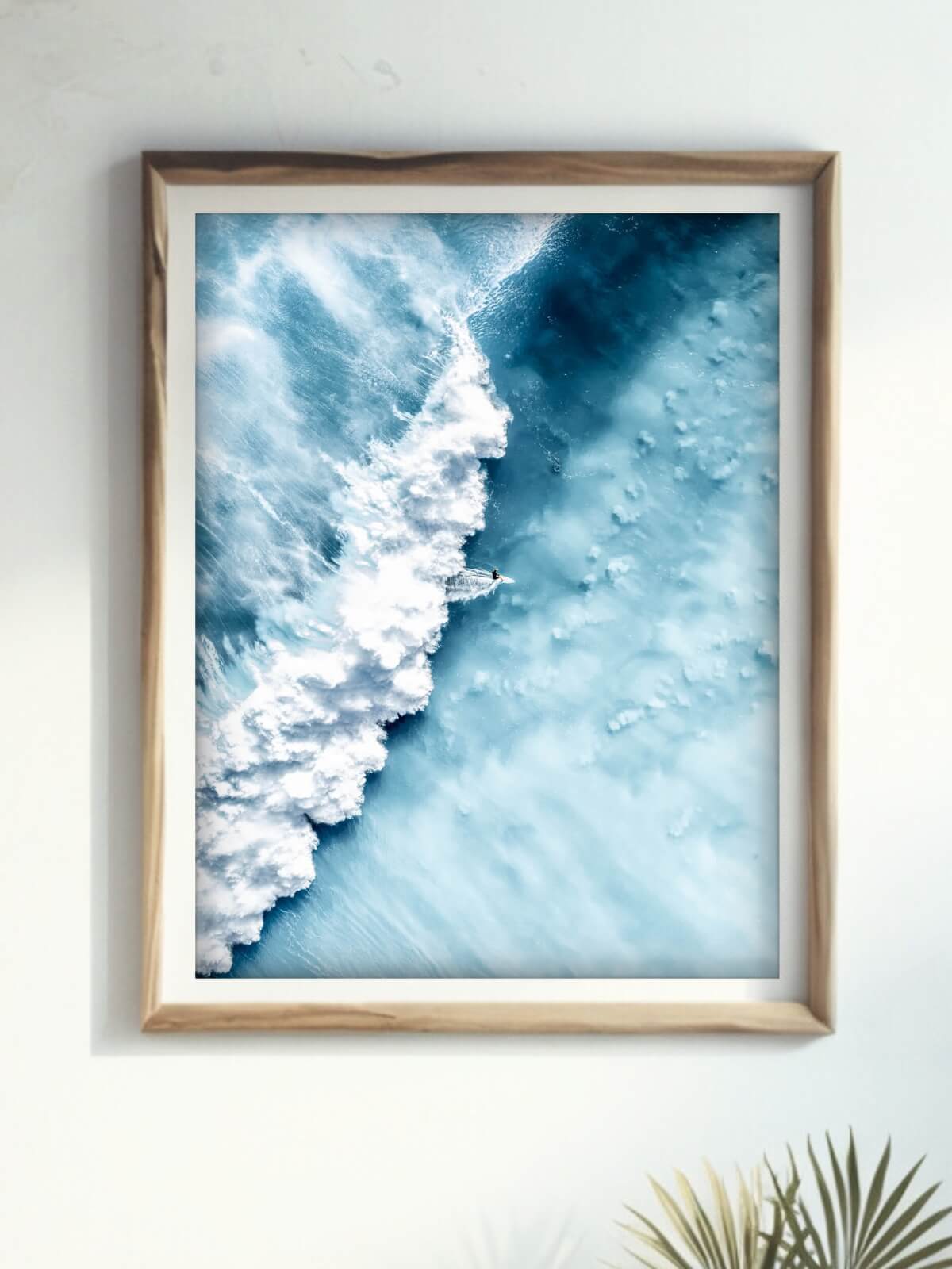 Framed abstract aerial photograph of a surfer riding a powerful wave at Bronte Beach in vivid blue tones