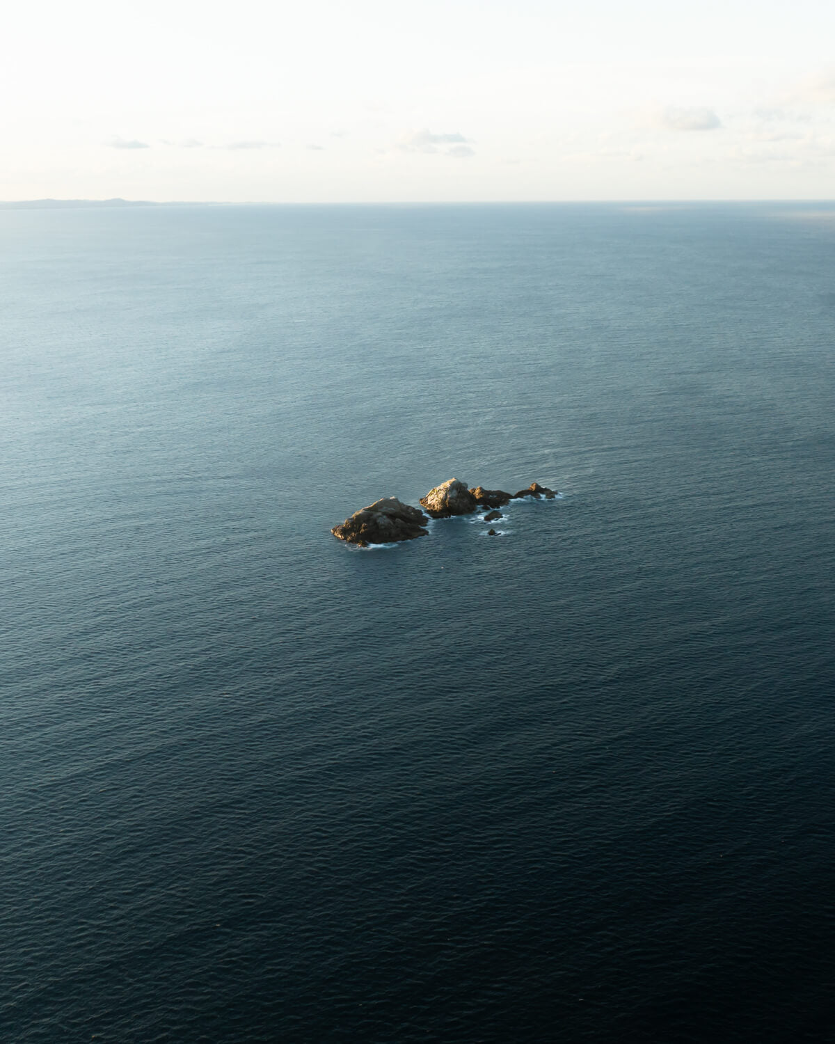 Minimalist photo of Julian Rocks in Byron Bay, known for its vibrant marine life and serene coastal setting.