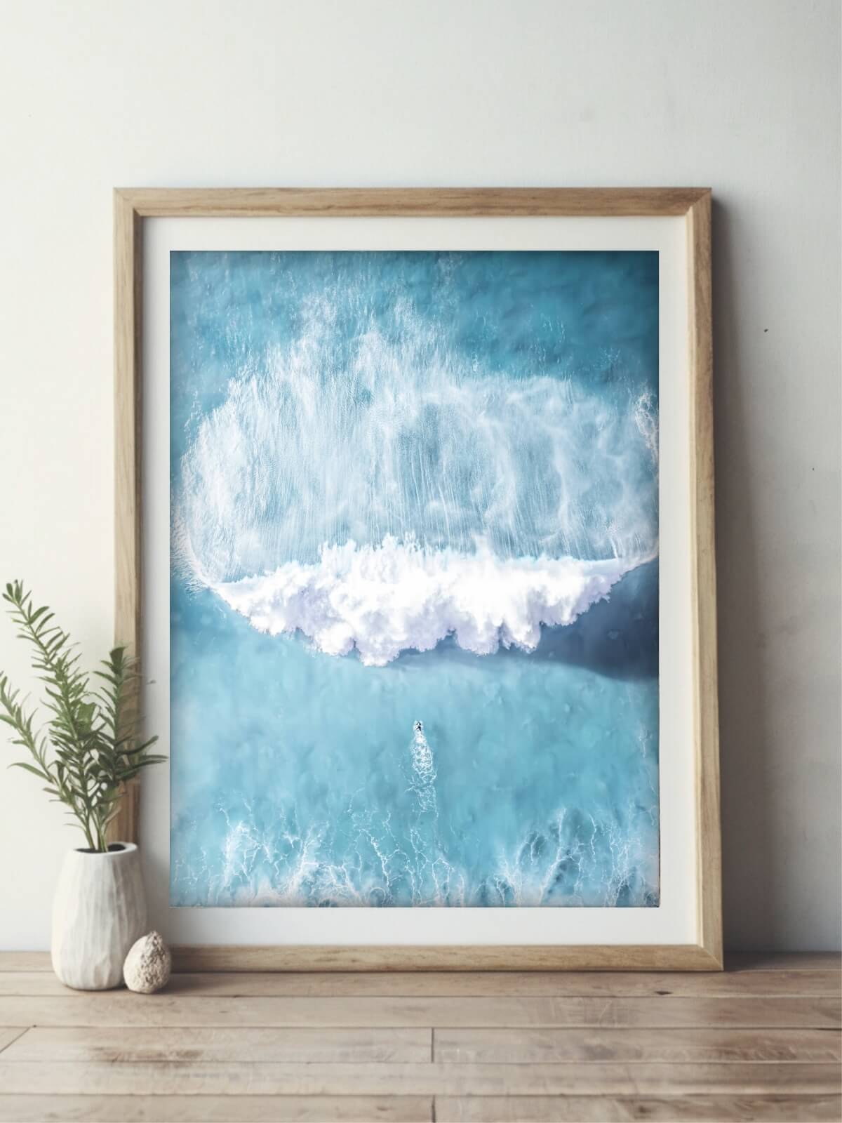 Aerial view of a surfer facing a massive wave at Bronte Beach, resembling a battle against nature