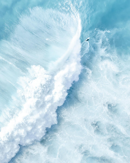 Aerial view of a surfer riding a powerful wave at Bronte Beach, with foamy spray creating an abstract cosmic effect.