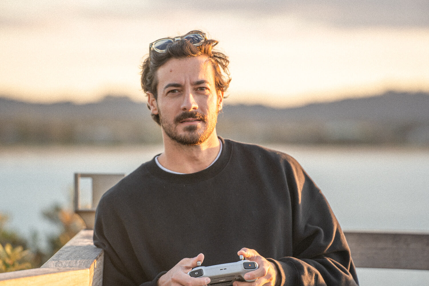 Portrait picture of the photographer Nicolas Letoublon holding his drone remote.