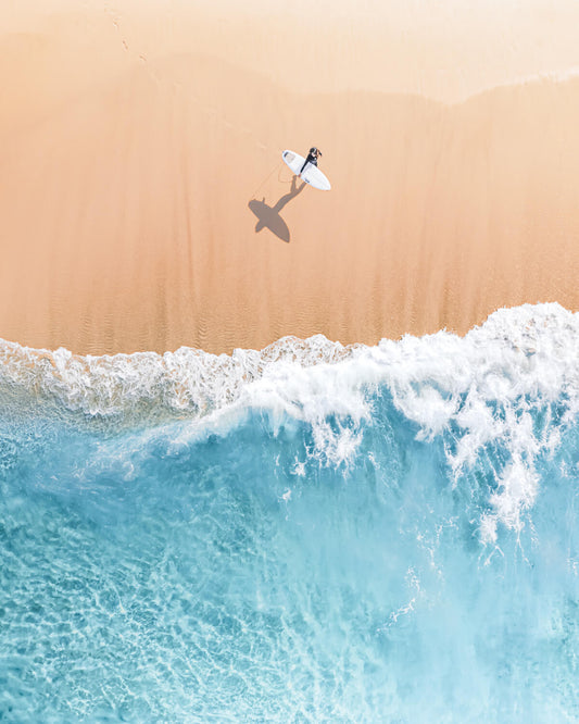 Photo print of a Surfer girl on Bronte Beach, Sydney, standing with her board near gentle waves on sandy shore.