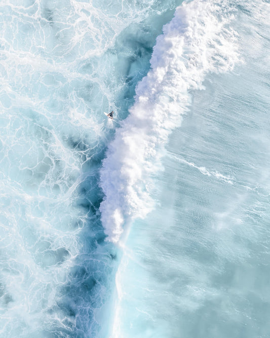 Aerial view of a surfer riding a powerful wave at Bronte Beach, Sydney, showcasing vibrant aqua tones and dynamic ocean movement.