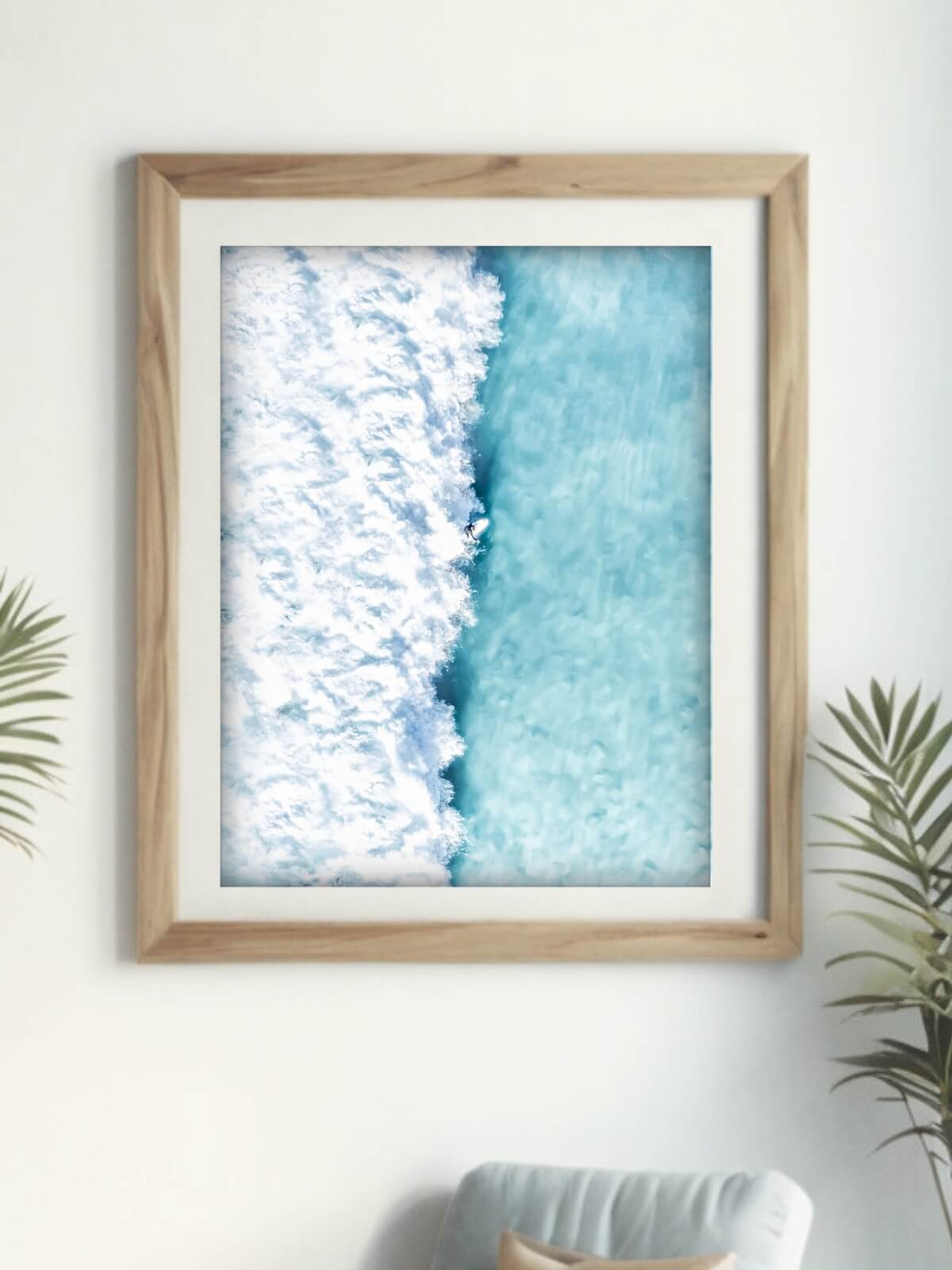 Framed aerial view of a surfer riding a powerful wave at Bronte Beach with contrasting blue ocean and white frothy surf